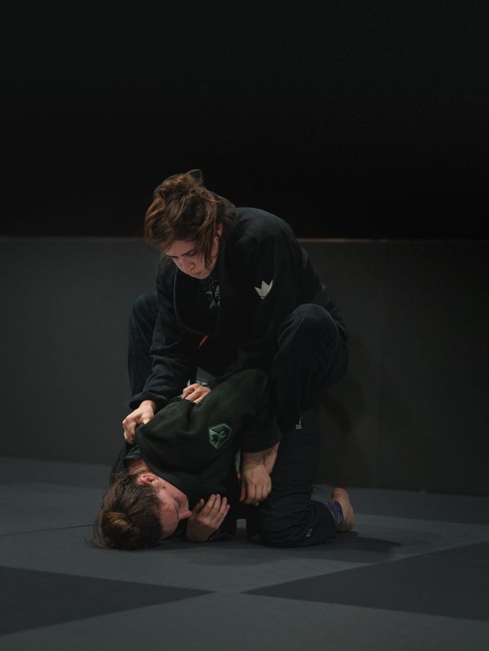 Two athletes engaged in intense Brazilian Jiu-Jitsu training in Buenos Aires dojo.